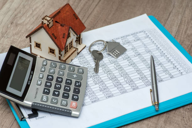 Relevé de compte, calculatrice, stylo et porte-clefs en forme de maison sur un bureau